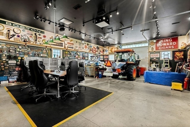 interior space featuring a workshop area, concrete flooring, and rail lighting