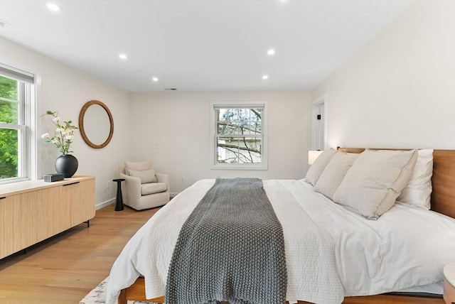 bedroom with multiple windows, light wood-style floors, recessed lighting, and baseboards
