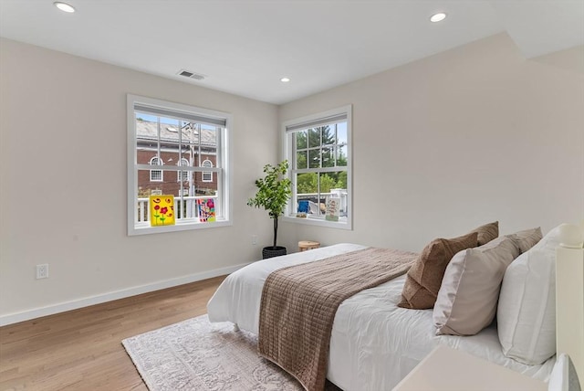 bedroom featuring multiple windows, wood finished floors, recessed lighting, and baseboards