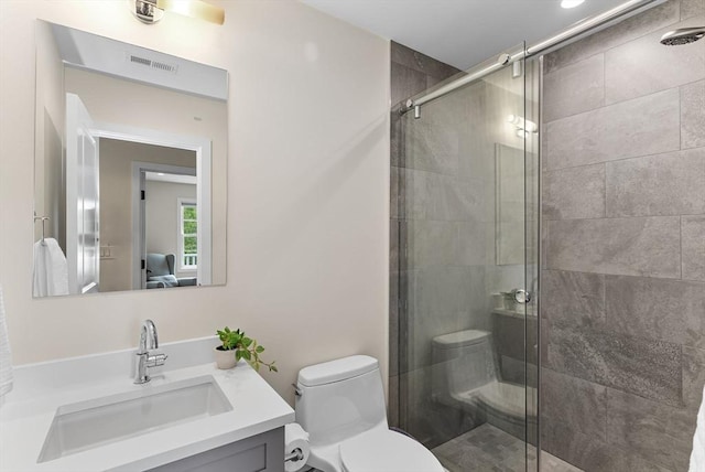 bathroom featuring a stall shower, toilet, and vanity