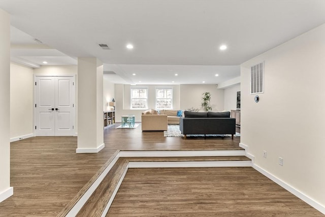 living room featuring wood finished floors, recessed lighting, and baseboards