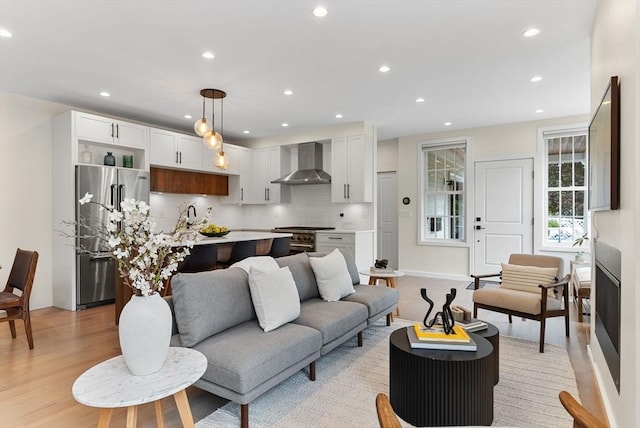 living area featuring light wood finished floors, recessed lighting, and baseboards
