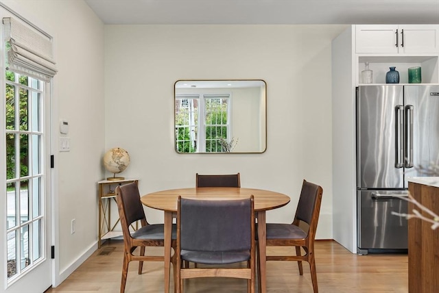 dining room with light wood-style floors and baseboards