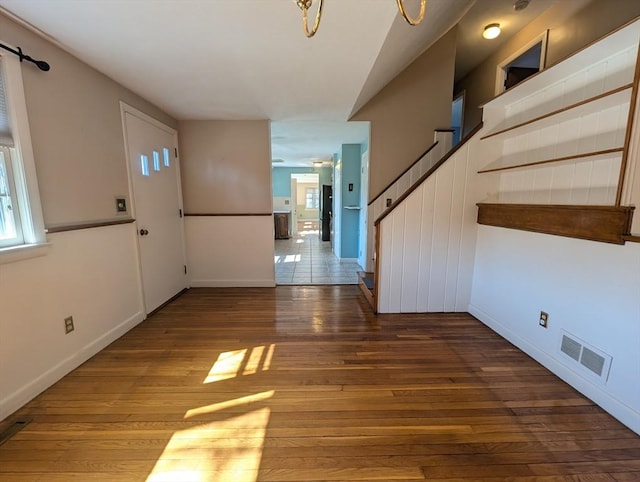 foyer with visible vents, wood-type flooring, and baseboards