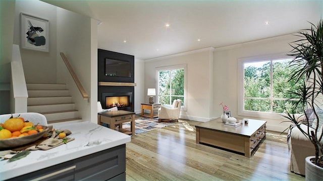 225 Middlesex Tpke Unit 101, Burlington, MA 01803 - living room with a large fireplace, crown molding, light wood finished floors, stairs, and recessed lighting