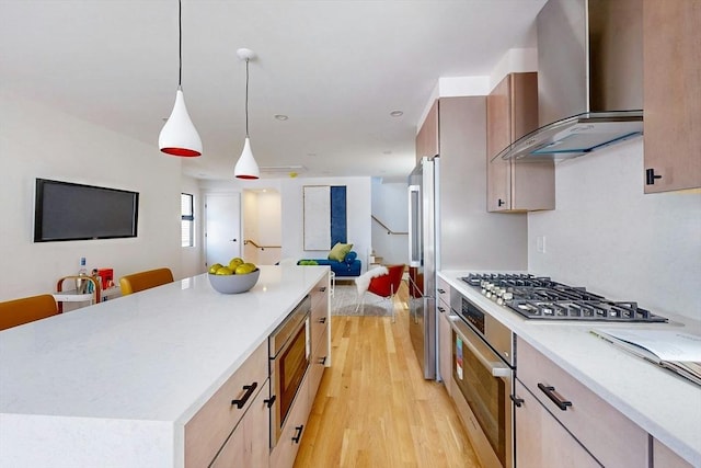 133 Charles St Unit 133, Cambridge, MA 02141 - kitchen with wall chimney range hood, open floor plan, stainless steel appliances, light wood-style flooring, and light countertops
