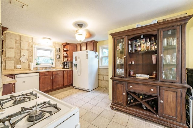 267 Maple St, East Longmeadow, MA 01028 - kitchen featuring white appliances, light tile patterned flooring, light countertops, tile walls, and glass insert cabinets