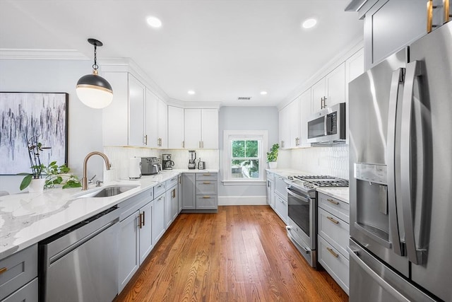 202 Middlesex Ave Unit 2, Medford, MA 02155 - kitchen featuring stainless steel appliances, a sink, gray cabinetry, tasteful backsplash, and wood finished floors