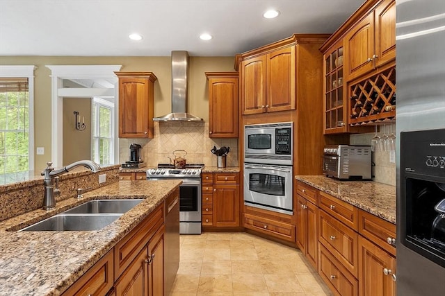 51 Drumlin Hill Rd, Bolton, MA 01740 - kitchen with wall chimney exhaust hood, appliances with stainless steel finishes, a sink, brown cabinets, and decorative backsplash