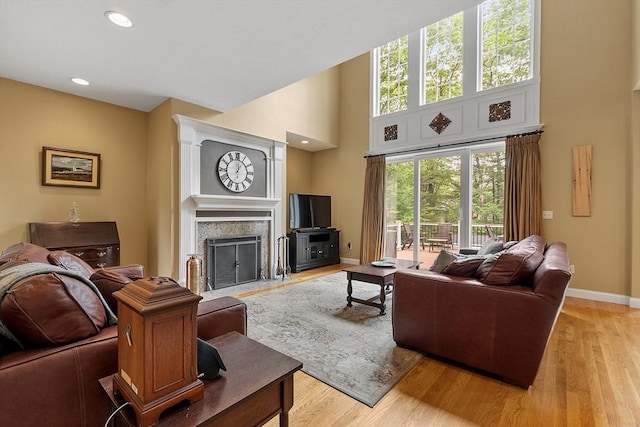 51 Drumlin Hill Rd, Bolton, MA 01740 - living room featuring a high ceiling, baseboards, light wood-style flooring, a fireplace with flush hearth, and recessed lighting