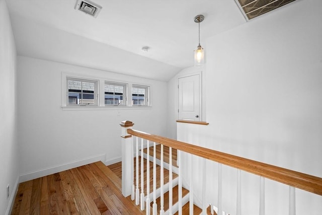 hallway with lofted ceiling and light hardwood / wood-style flooring