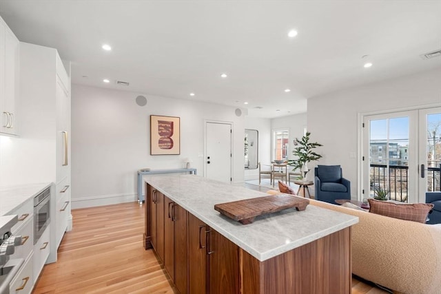 60 Williams St Unit 402, Boston, MA 02130 - kitchen featuring open floor plan, light wood finished floors, a kitchen island, recessed lighting, and stainless steel microwave