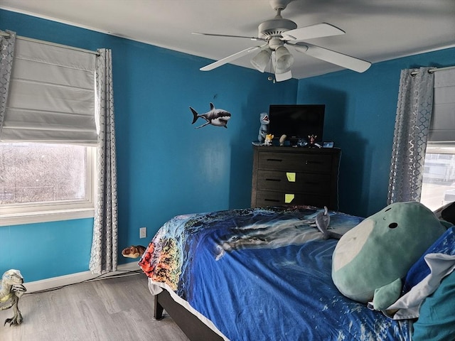 bedroom featuring baseboards, ceiling fan, and wood finished floors