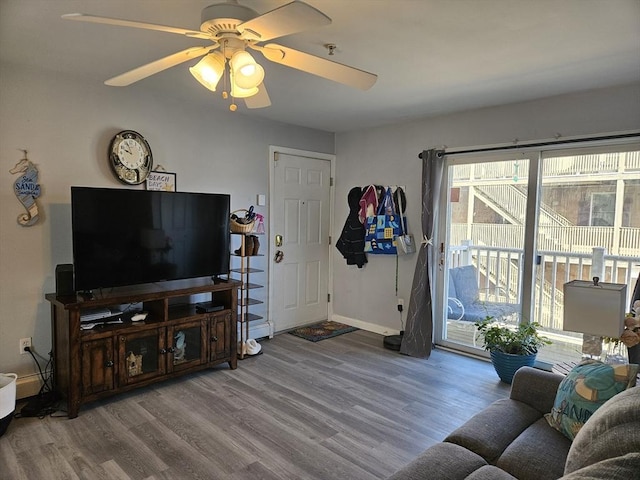 living area featuring ceiling fan, baseboards, and wood finished floors