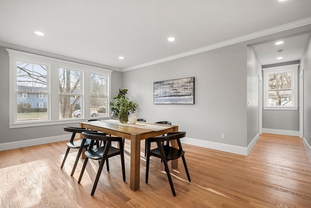 dining space with a healthy amount of sunlight, light hardwood / wood-style floors, and ornamental molding