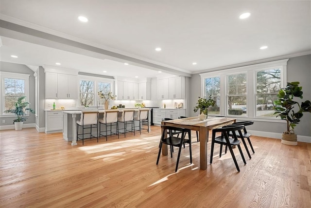 dining space with light wood-type flooring and crown molding