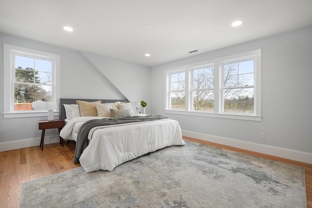 bedroom featuring hardwood / wood-style flooring and multiple windows