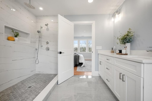 bathroom featuring tiled shower and vanity