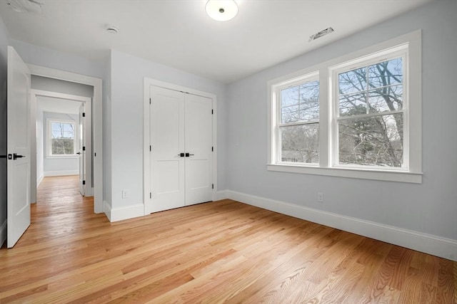 unfurnished bedroom featuring light wood-type flooring and a closet