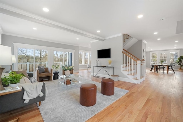 living room with beamed ceiling, light wood-type flooring, and ornamental molding