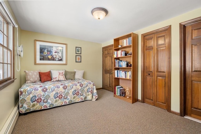 bedroom with carpet floors and a baseboard heating unit