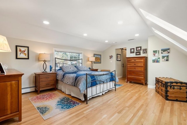 bedroom with lofted ceiling with skylight, light hardwood / wood-style floors, and a baseboard heating unit