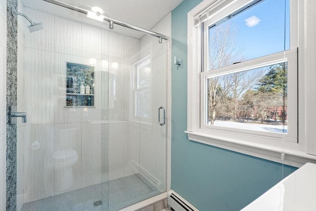 bathroom with baseboard heating, toilet, and a shower with shower door