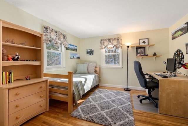 bedroom with multiple windows and light hardwood / wood-style flooring