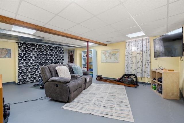 living room with concrete flooring and a drop ceiling