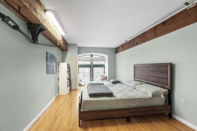 bedroom featuring a textured ceiling and light hardwood / wood-style floors