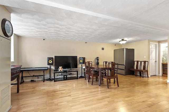 dining space featuring a textured ceiling and light hardwood / wood-style flooring