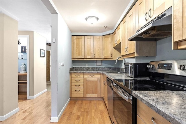 kitchen featuring stainless steel appliances, light brown cabinets, sink, and light hardwood / wood-style floors