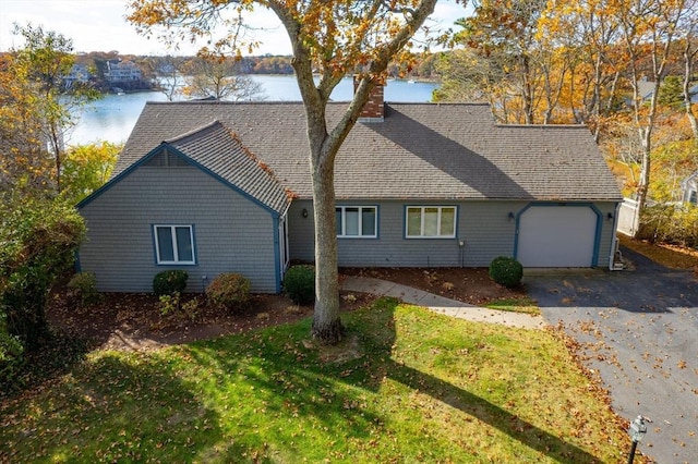 view of side of property with a water view and a lawn