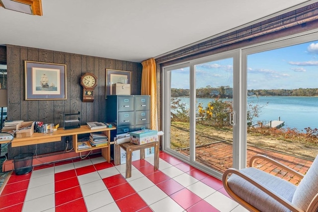 dining area with a water view, tile patterned floors, and wooden walls