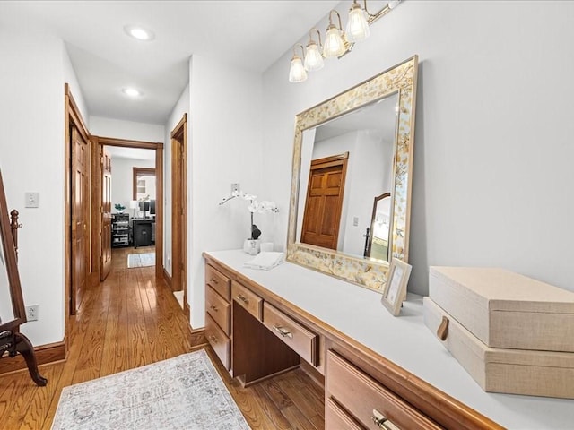 bathroom featuring recessed lighting, vanity, baseboards, and wood finished floors