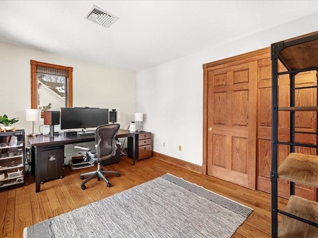 office featuring baseboards, visible vents, and wood finished floors