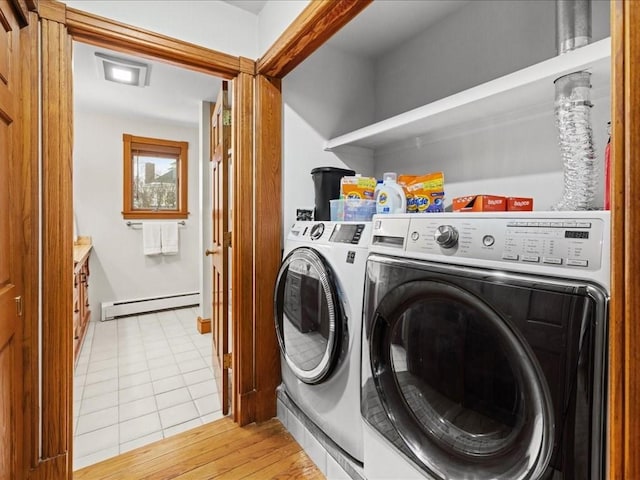 laundry room with light tile patterned floors, laundry area, baseboard heating, and washing machine and dryer