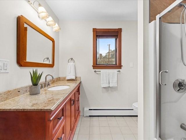 bathroom featuring toilet, vanity, a shower, baseboard heating, and tile patterned floors