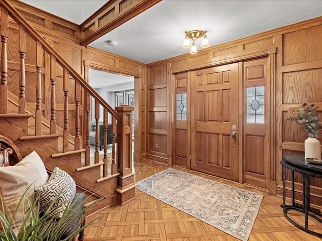 entryway featuring stairway and wood walls