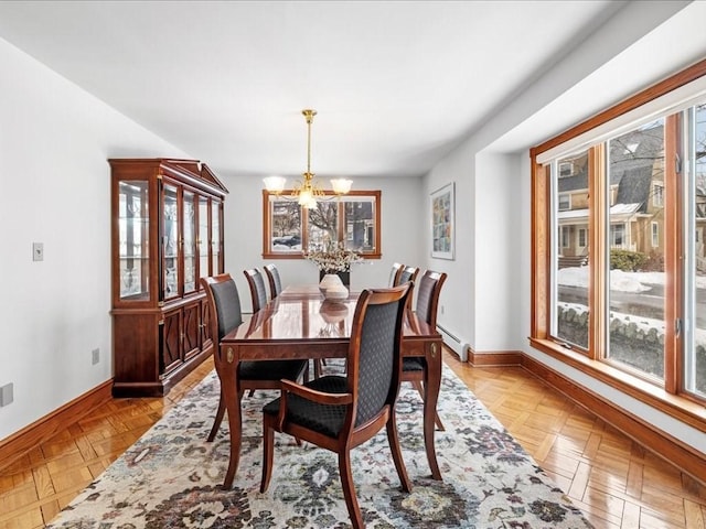 dining space featuring a baseboard radiator, a notable chandelier, and baseboards