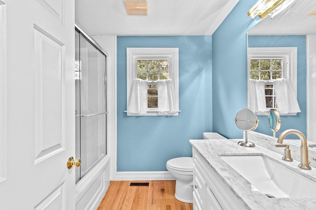 16 Old Colony Way, Whitman, MA 02382 - full bath featuring toilet, wood finished floors, vanity, baseboards, and shower / bath combination with glass door