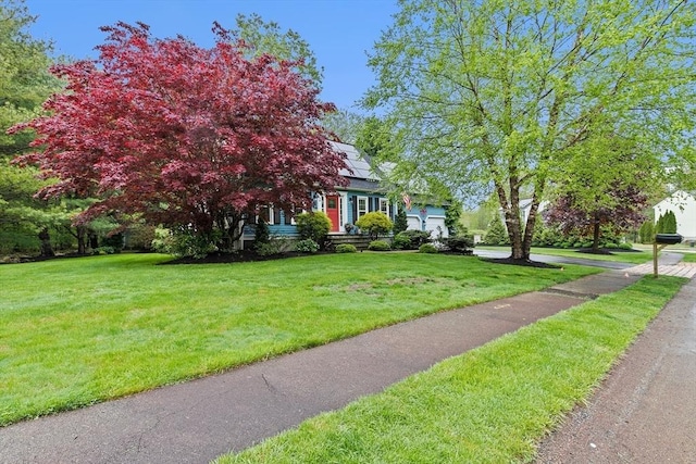 16 Old Colony Way, Whitman, MA 02382 - view of property hidden behind natural elements with an attached garage, solar panels, and a front lawn