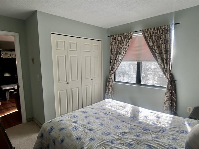 carpeted bedroom featuring a closet and a textured ceiling