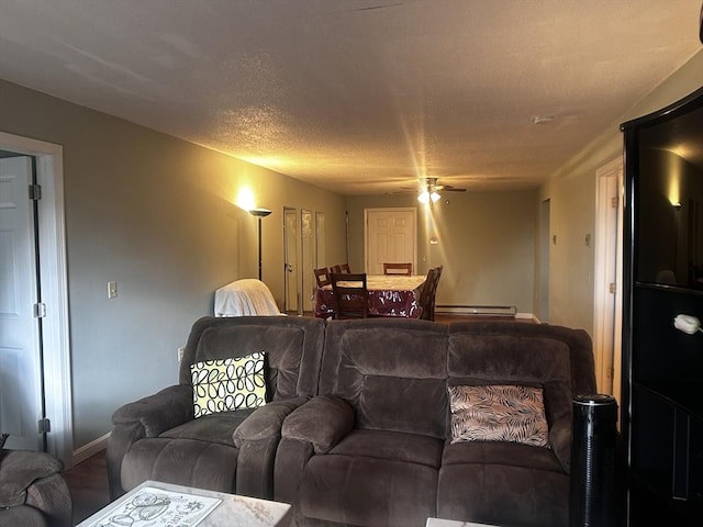 living room with ceiling fan, a baseboard radiator, and a textured ceiling