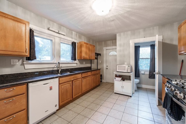 71 Daviston St, Springfield, MA 01108 - kitchen featuring white appliances, a sink, a textured ceiling, light tile patterned floors, and brown cabinets