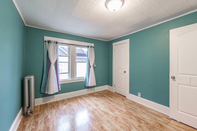 71 Daviston St, Springfield, MA 01108 - unfurnished bedroom featuring crown molding, radiator, wood finished floors, and baseboards