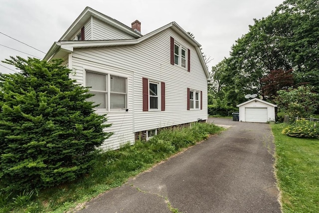 71 Daviston St, Springfield, MA 01108 - view of front of house with a garage, an outdoor structure, a chimney, and asphalt driveway