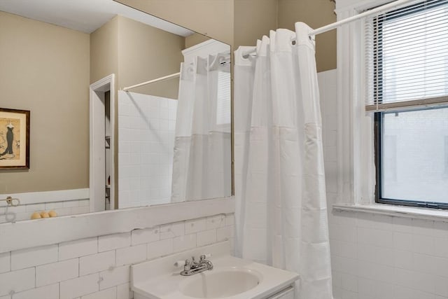 bathroom featuring vanity, tile walls, and walk in shower