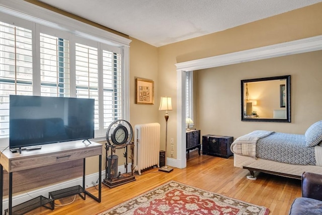 bedroom with hardwood / wood-style floors and radiator heating unit