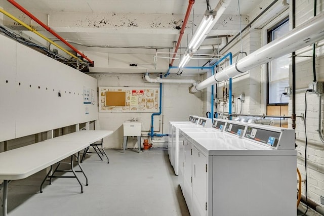 clothes washing area featuring independent washer and dryer and sink